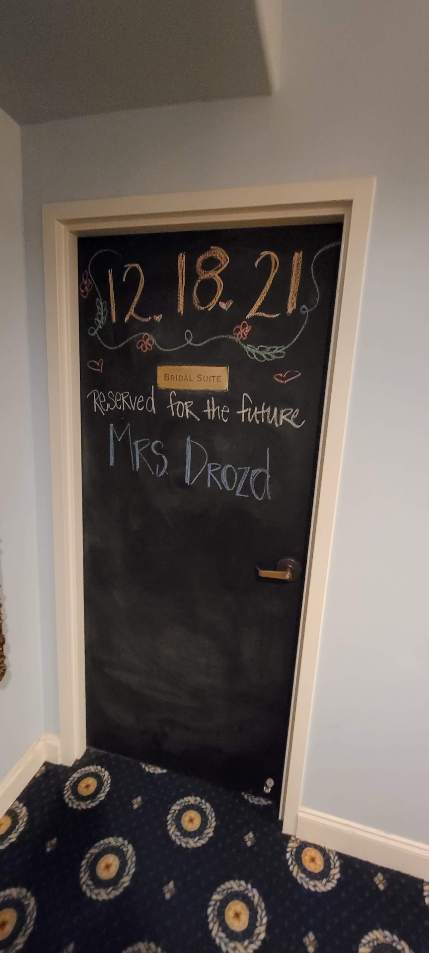 Bridal suite door chalkboard reading 'Reserved for the future Mrs. Drozd, 12.18.21' from the wedding of Dustin Michael Drozd.