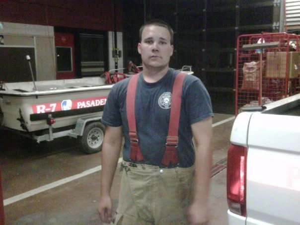 Young Dustin Michael Drozd in Pasadena, Texas volunteer firefighter turnout gear and suspenders at the station.