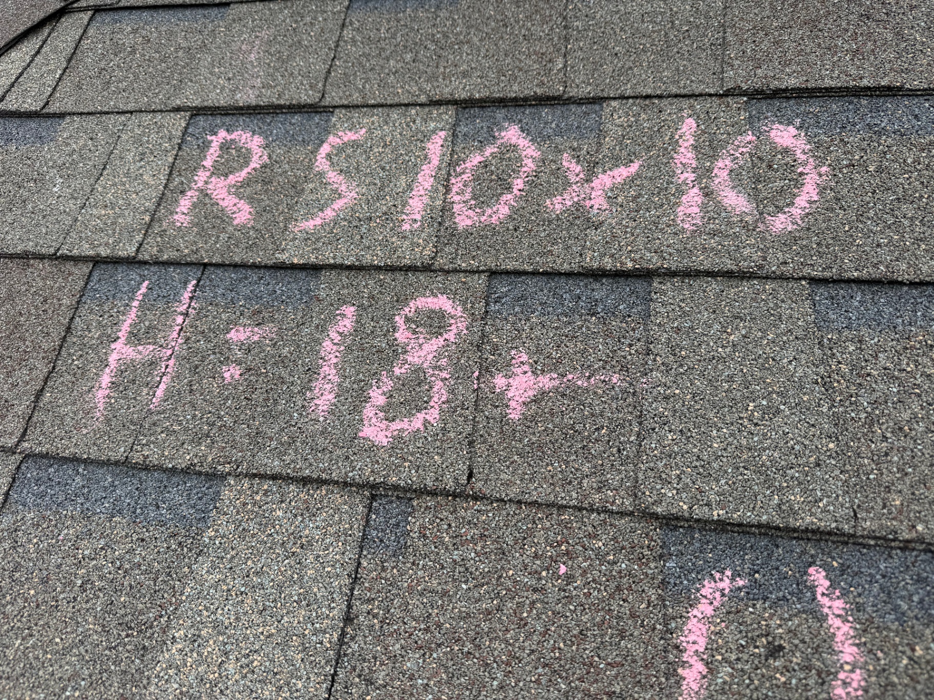 Close-up of pink chalk inspection markings on asphalt shingles documented by Dustin Drozd of Texas Roof Guardians.